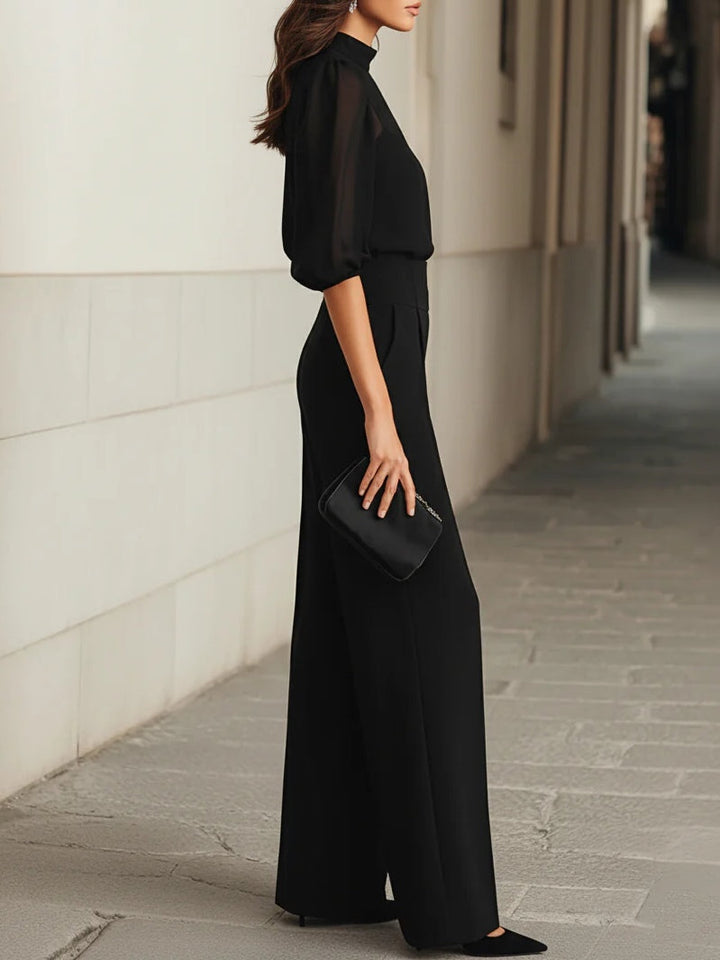 Conjunto de tres piezas negras, compuesto por una camiseta de tirantes transparente y pantalones de pierna ancha